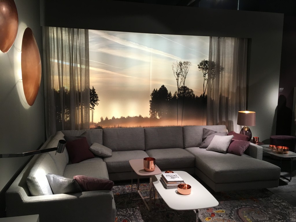 Dunkle Wände mit Leuchtschalen aus Kupfer, eine einladende Couch mit genug Platz zum entspannen. So gemütlich kann es zu Hause sein.