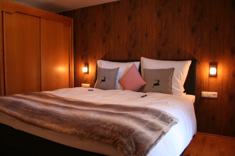 Ein Schlafzimmer der Ferienwohnung im Landhaus Math mit unserer Tapete in Holzdielenoptik