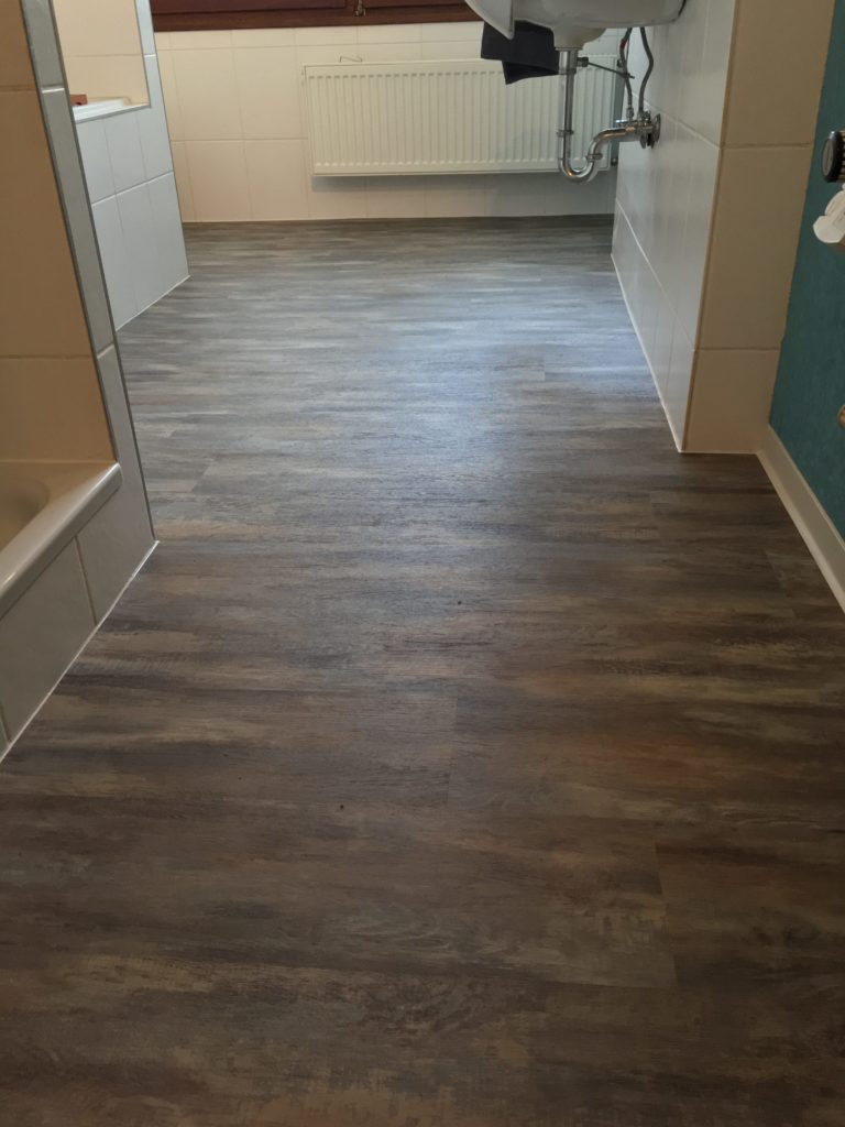 Badezimmer mit Vinylboden in dunkler Holzoptik