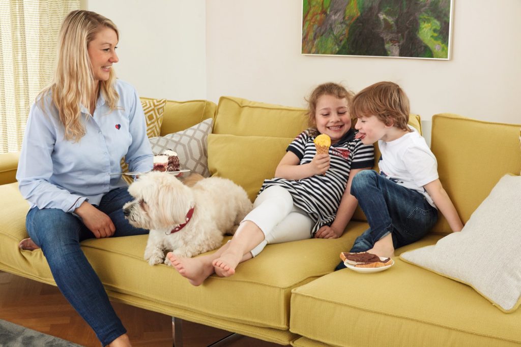 Familie mit Hund auf einem neu bezogenen Sofa in Gelb